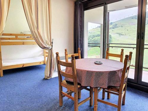 une salle à manger avec une table et des chaises et une fenêtre dans l'établissement Studio lumineux au centre avec balcon et piscine - FR-1-267-223, au Corbier