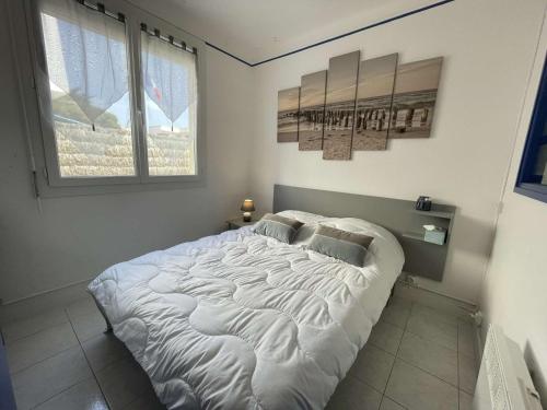 - un grand lit blanc dans une chambre avec 2 fenêtres dans l'établissement Appartement Moderne 2 Pièces + Cabine, Terrasse, Proche Plage – Saint-Jean-de-Monts - FR-1-224C-204, à Saint-Jean-de-Monts