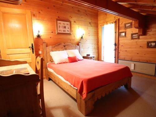 une chambre avec un lit dans une cabane en rondins dans l'établissement Les Gets - Chalet chaleureux pour 8 personnes - FR-1-623-314, aux Gets