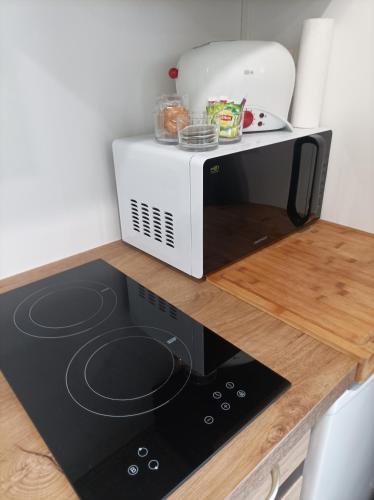 a microwave sitting on top of a kitchen counter at Chambre aménagé en studio in Cers