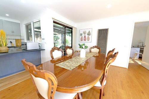 a dining room with a wooden table and chairs at Best Location Entire House Staycation Parkland Surrounding in Hallam