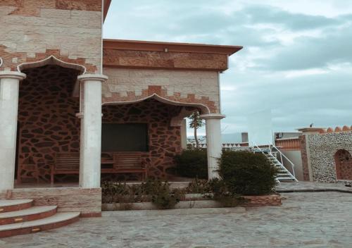 un edificio in mattoni con un portico e una scala di استراحة ابهار a Jadīd