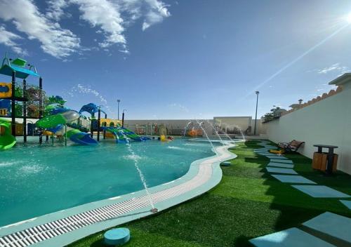 una piscina con un parco acquatico con uno scivolo d'acqua di استراحة ابهار a Jadīd