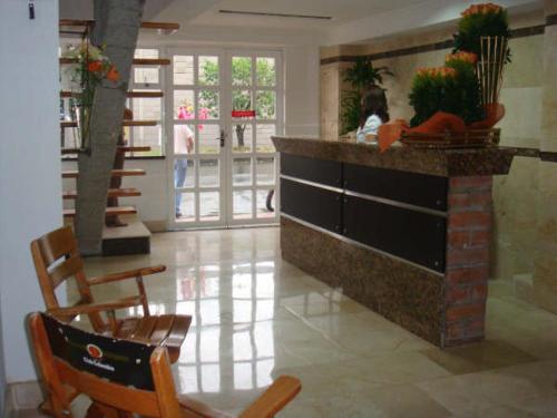 a lobby with a counter with chairs and a table at Gran Caribe Hotel in Medellín