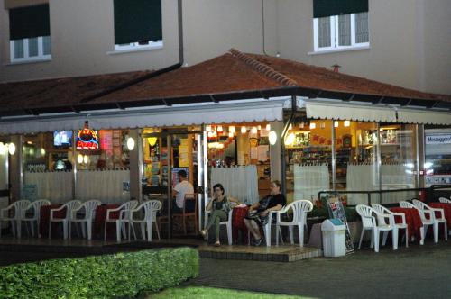 a group of people sitting outside a restaurant at night at Hotel Da Angela in Sedegliano