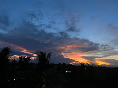 a sunset with the sky in the background at La Plumerias in Moalboal
