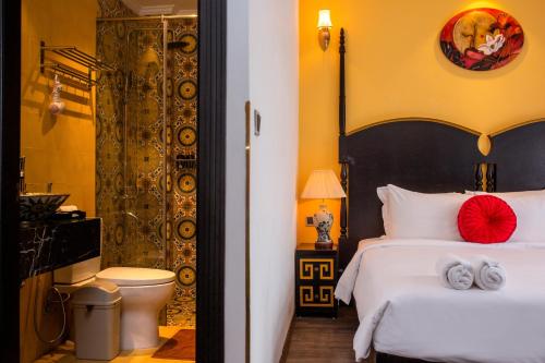 a bedroom with a bed with a red pillow on it at Hanoi Center Silk Boutique Hotel & Travel in Hanoi