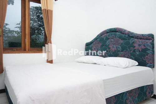 Ένα ή περισσότερα κρεβάτια σε δωμάτιο στο Villa Handayani Songgoriti RedPartner