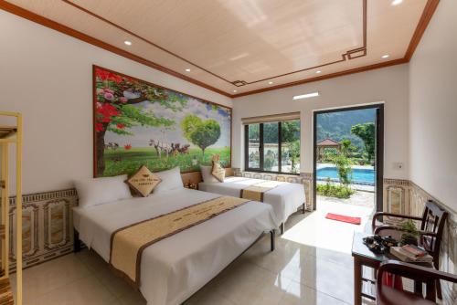 2 Betten in einem Schlafzimmer mit Wandgemälde in der Unterkunft Tan Dinh Farmstay in Ninh Bình
