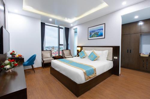Pokój hotelowy z dużym łóżkiem i biurkiem w obiekcie SALA HOTEL MÓNG CÁI w mieście Móng Cái