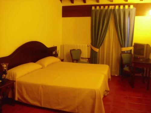 una camera d'albergo con letto e TV di Hostal La Mancha a Tarazona de la Mancha