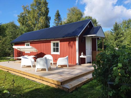 a red shed with chairs and a deck at Lodge Lagom - Luxury guesthouse in Hammarstrand