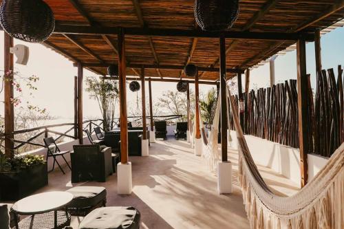 a patio area with chairs, tables, and umbrellas at Hotel Sun Ha Bacalar in Bacalar