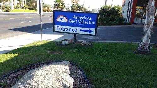 a sign in the grass next to a street at Studio 6 Suites Delano, CA in Delano
