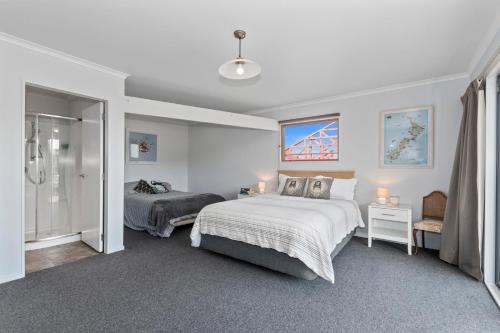 een slaapkamer met 2 bedden en een inloopdouche bij Ruakaka River Retreat - Ruakaka Holiday Home in Ruakaka