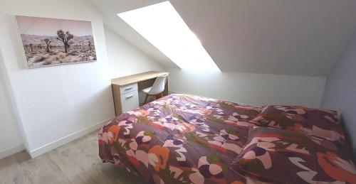 ソミュールにあるHistoire de Loire - Le Futreauのベッドルーム1室(花の咲く掛け布団付きのベッド1台付)