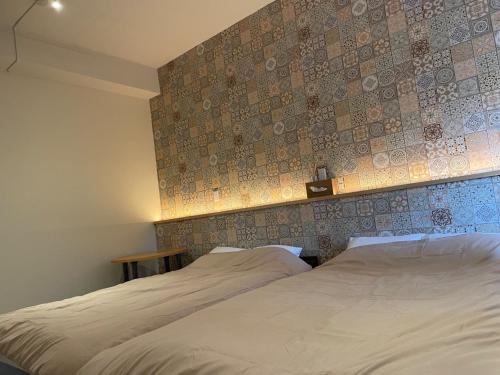 1 dormitorio con 2 camas y una pared con azulejos en Small Resort Shima - Vacation STAY 96429v, en Shima