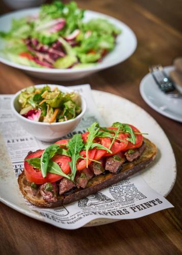 a sandwich on a plate with a salad on a table at JW Marriott Phuket Resort and Spa in Mai Khao Beach