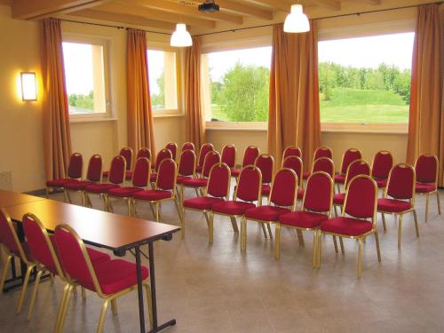 a conference room with red chairs and a table at Golf Hotel Cavaglià in Cavaglià