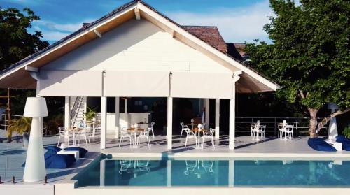 a pavilion with tables and chairs next to a pool at Bluerama - Adults Only in Haad Pleayleam