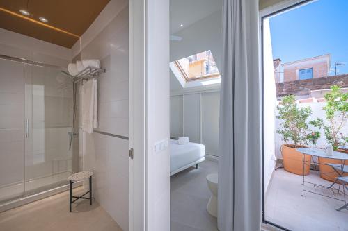 uma casa de banho com um chuveiro, um WC e uma mesa em Málaga Centro Terraza 4-D em Málaga