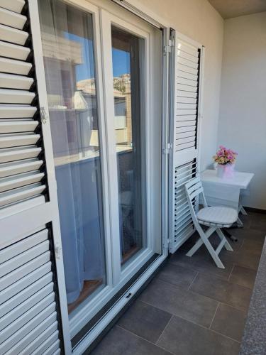 a balcony with sliding glass doors and a chair at APARTMENT ELI in Pag