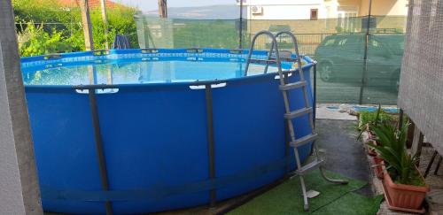 a large blue pool with a ladder around it at Petkovic Apartmani 3 in Tivat