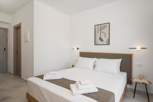 a bedroom with a large white bed with towels on it at Kallistefan in Kissamos