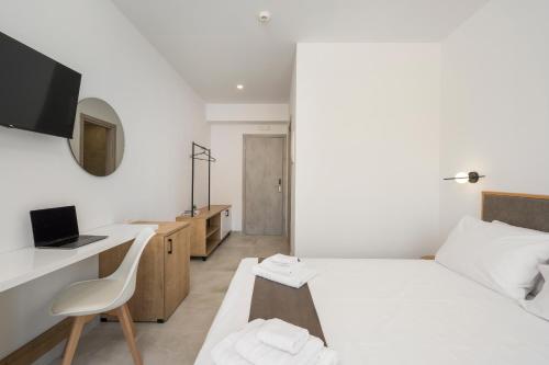 a bedroom with a bed and a desk with a computer at Kallistefan in Kissamos