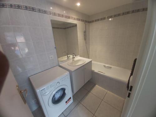une salle de bain avec une machine à laver et un lavabo dans l'établissement Centre, Grand T2 balcon Pkg, plage gare 600m, Trés calme, à Arcachon