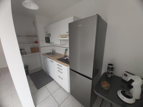 une petite cuisine avec un réfrigérateur et une table dans l'établissement Centre, Grand T2 balcon Pkg, plage gare 600m, Trés calme, à Arcachon