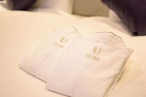two white towels sitting on top of a bed at Via Inn Kanazawa in Kanazawa