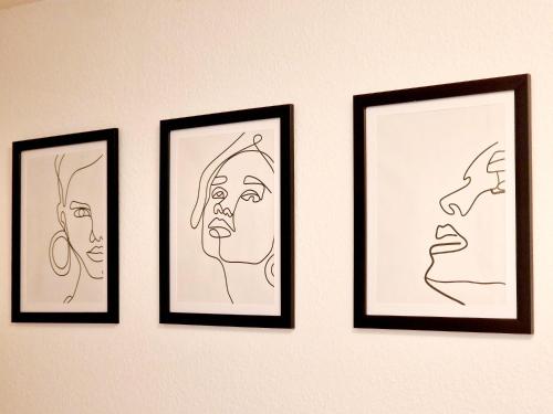 four framed drawings of faces are on a wall at Relax Wohnung in Bensheim Auerbach in Bensheim