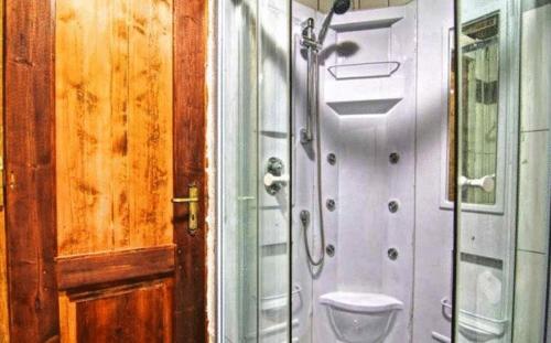 a bathroom with a shower next to a door at Stone Village Hotel Apartments in Balíon