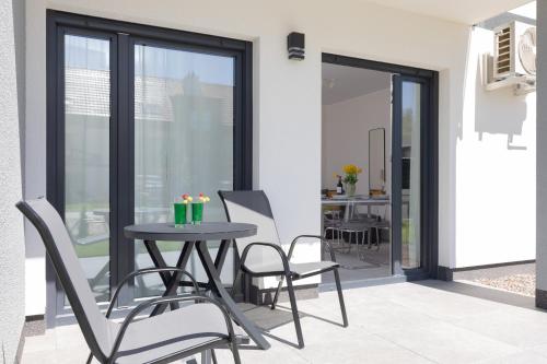 a patio with a table and chairs on a balcony at Silamar Niechorze Zaciszna by Noclegi Renters in Niechorze
