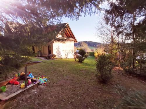 a yard with a sandbox with toys and a house at Ferienwohnungen Kremser bei Spiegelau Eppenschlag in Eppenschlag