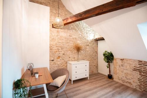 Cet appartement mansardé comprend une table et des chaises en bois. dans l'établissement Duplex colombage centre historique d'Orléans, à Orléans