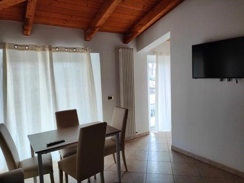 une salle à manger avec une table, des chaises et une télévision dans l'établissement Da Cate - Appartamento al mare, à Grottammare
