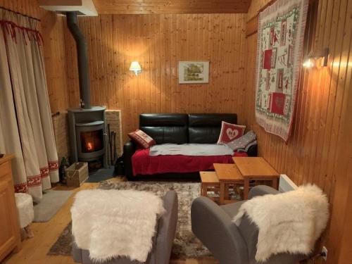 sala de estar con sofá y chimenea en Chalet proche Morzine et lac Léman WIFI offert, en Le Biot