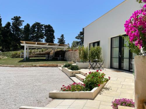 un edificio bianco con alcuni fiori in un cortile di Villa Anna Maria Otranto a Otranto