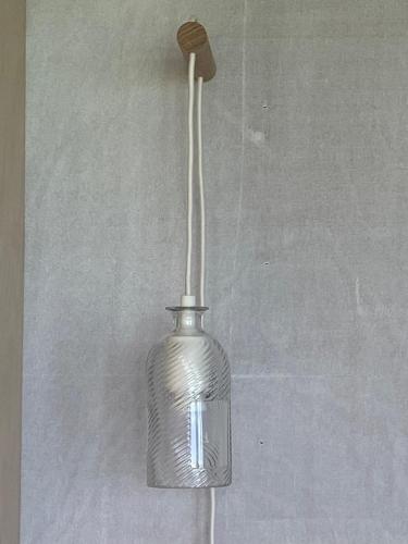 a glass vase with a wooden stick in it at Unique luxurious cabin on sea view working croft in Garrabost