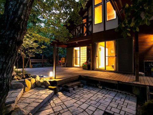 a house with a bench in front of a tree at びわ湖ハイドアウト in Takashima