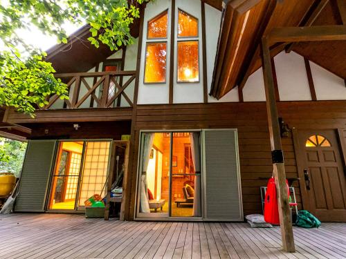 a house with a front porch with a deck at びわ湖ハイドアウト in Takashima
