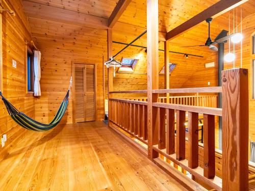 a room with a hammock in a log cabin at びわ湖ハイドアウト in Takashima