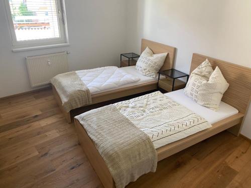 two beds in a room with wooden floors at Gamlitz - RaStra Top 7 in Gamlitz