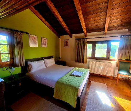 ein Schlafzimmer mit einem Bett und zwei Fenstern in der Unterkunft Guesthouse Odysseas in Kerasea