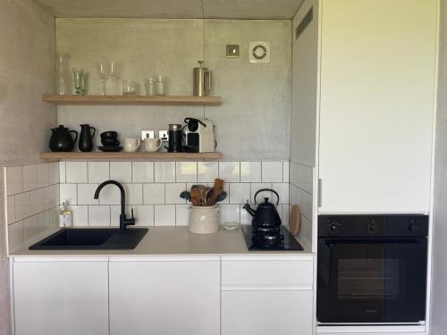 a kitchen with a sink and a stove at Unique luxurious cabin on sea view working croft in Garrabost