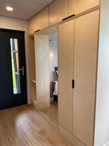 a room with a closet and a door to a bedroom at Unique luxurious cabin on sea view working croft in Garrabost