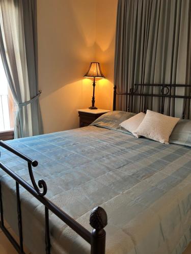 a bedroom with a bed with a lamp and a window at Xenonas Nikia in Yerákion