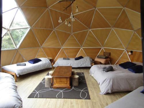 Zimmer mit 3 Betten und einem Tisch in der Unterkunft La Bergerie du Plateau in Cros-de-Géorand